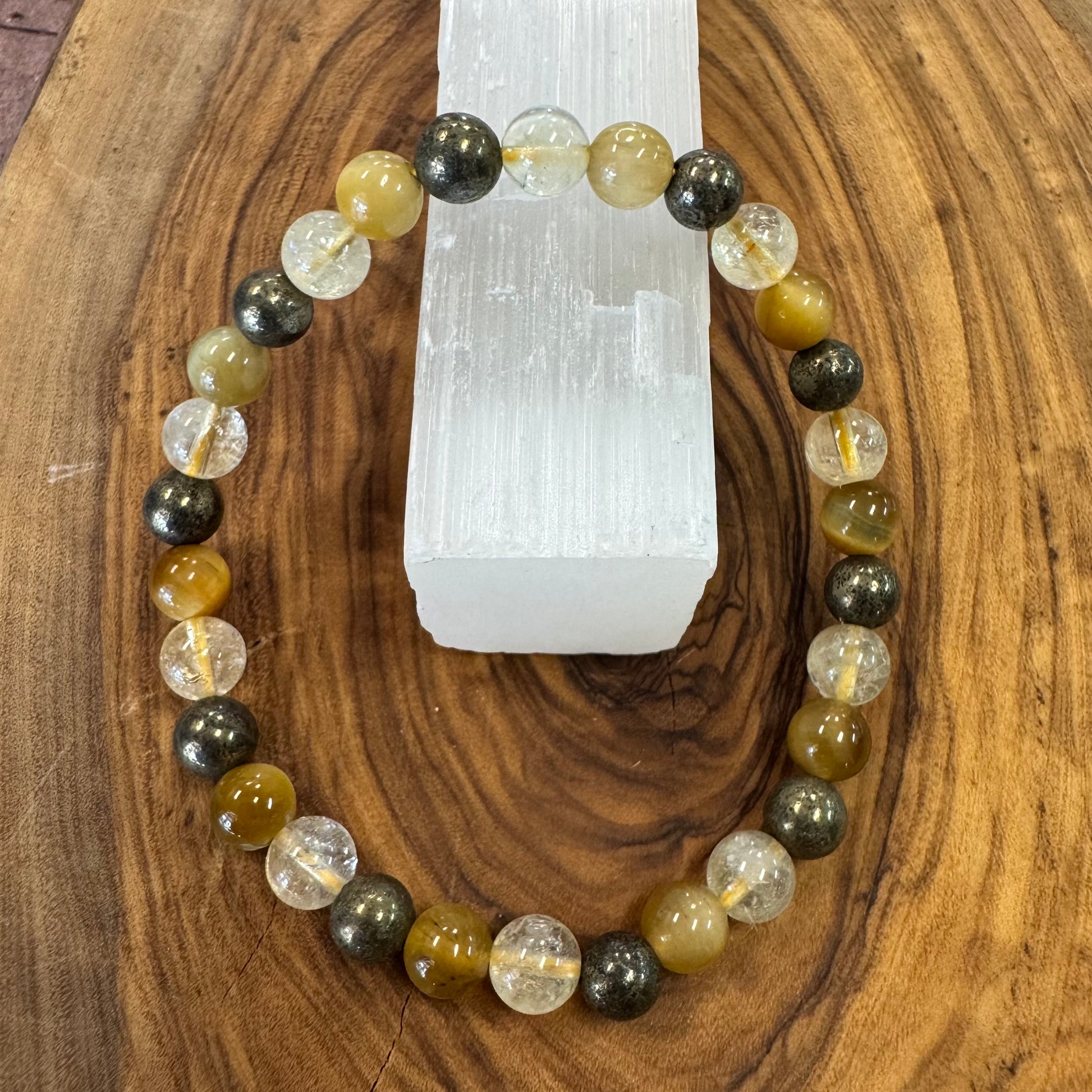 Multicolored beaded bracelet on a wooden surface with a crystal