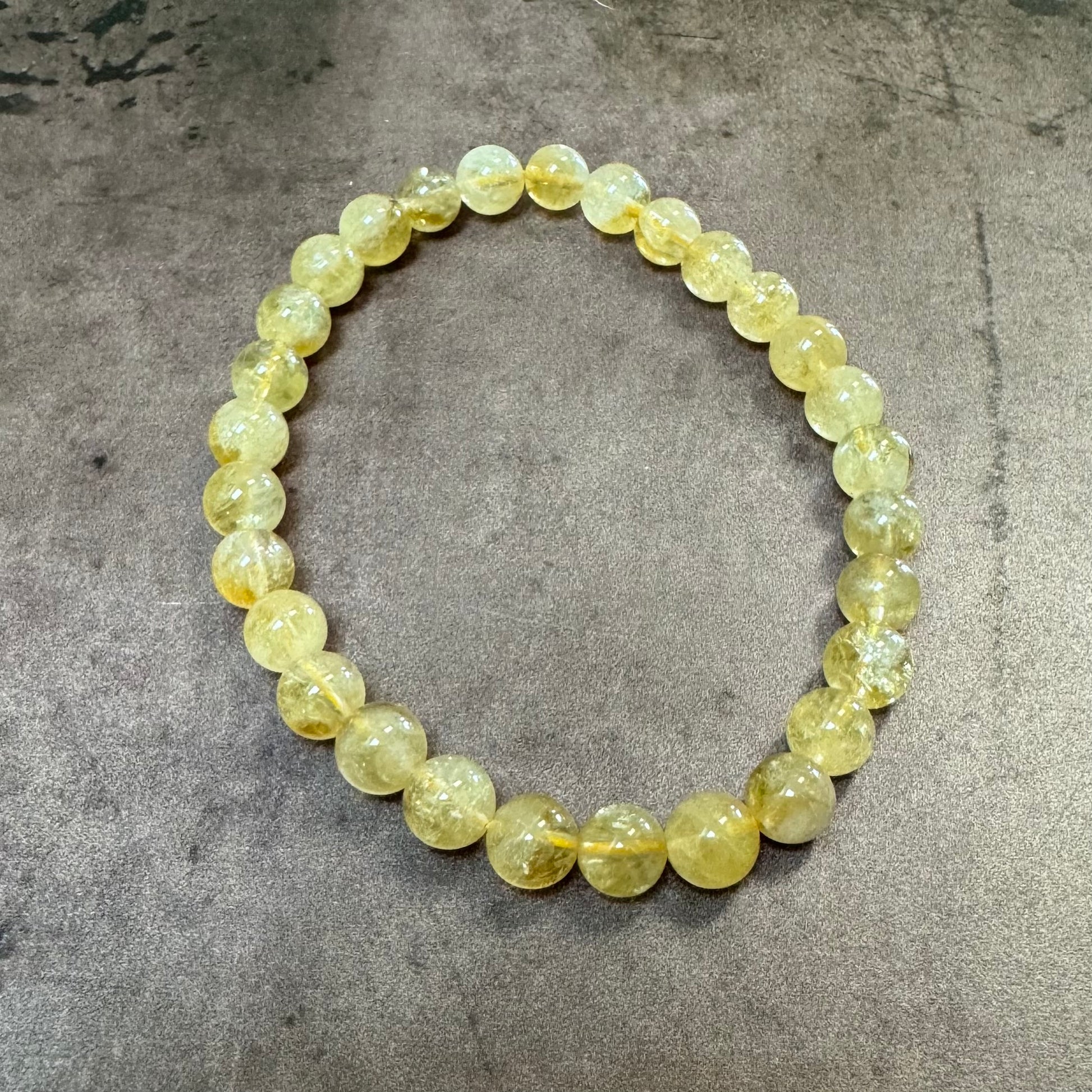 Beaded bracelet with yellow stones on a gray surface