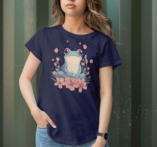 True Navy garment-dyed t-shirt with a hand-drawn frog in wildflowers graphic, worn against a green garden background