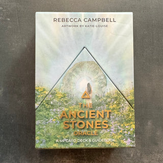 A book titled 'The Ancient Stones Oracle' by Rebecca Campbell and Katie-Louise, featuring a woman meditating in a triangle with a sun and moon background, surrounded by flowers. The book is a guidebook and card set for the Ancient Stones Oracle, with a 4-card deck and a guidebook.