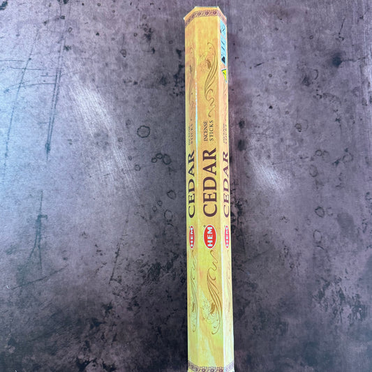 A pack of Cedar Hem Hexagonal incense with branding and product information visible on the packaging.