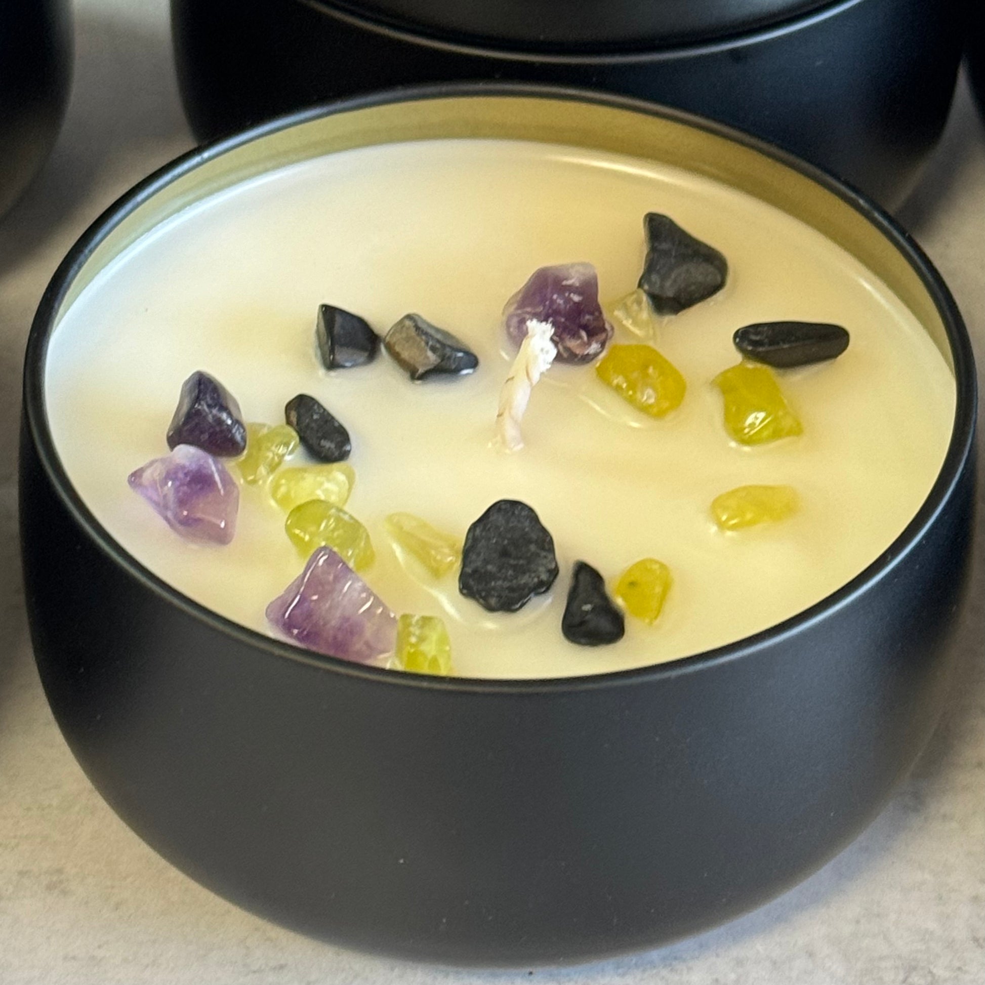 Close up of candle with amethyst, jade and black tourmaline