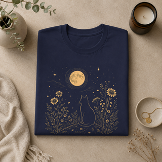 Folded Navy Moonlit Cat tee with a gold cat among wildflowers under a full moon, styled with decorative items