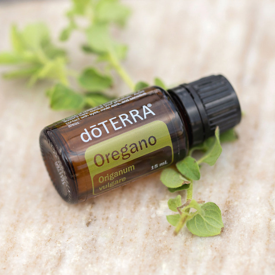 doTERRA Oregano essential oil bottle with oregano leaves on a light background