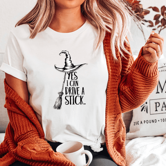 Person wearing a white t-shirt with a graphic design and text, sitting on a couch.