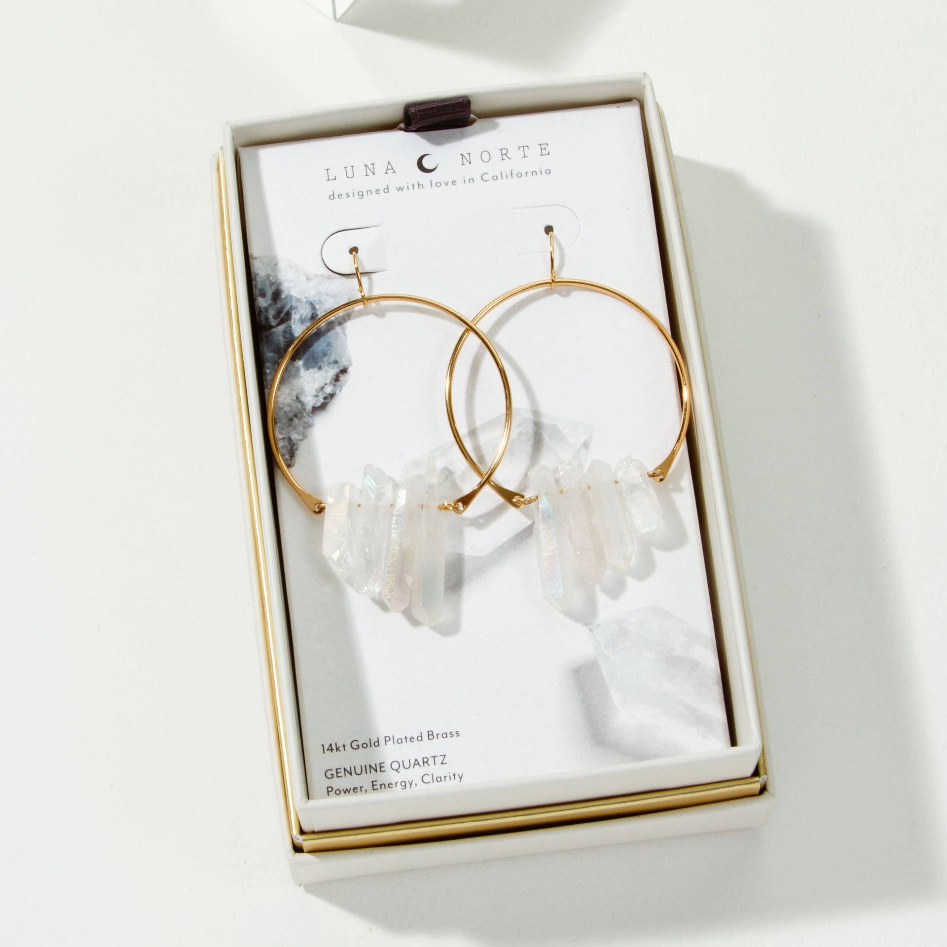 Gold hoop earrings with crystal elements on a branded card in a box