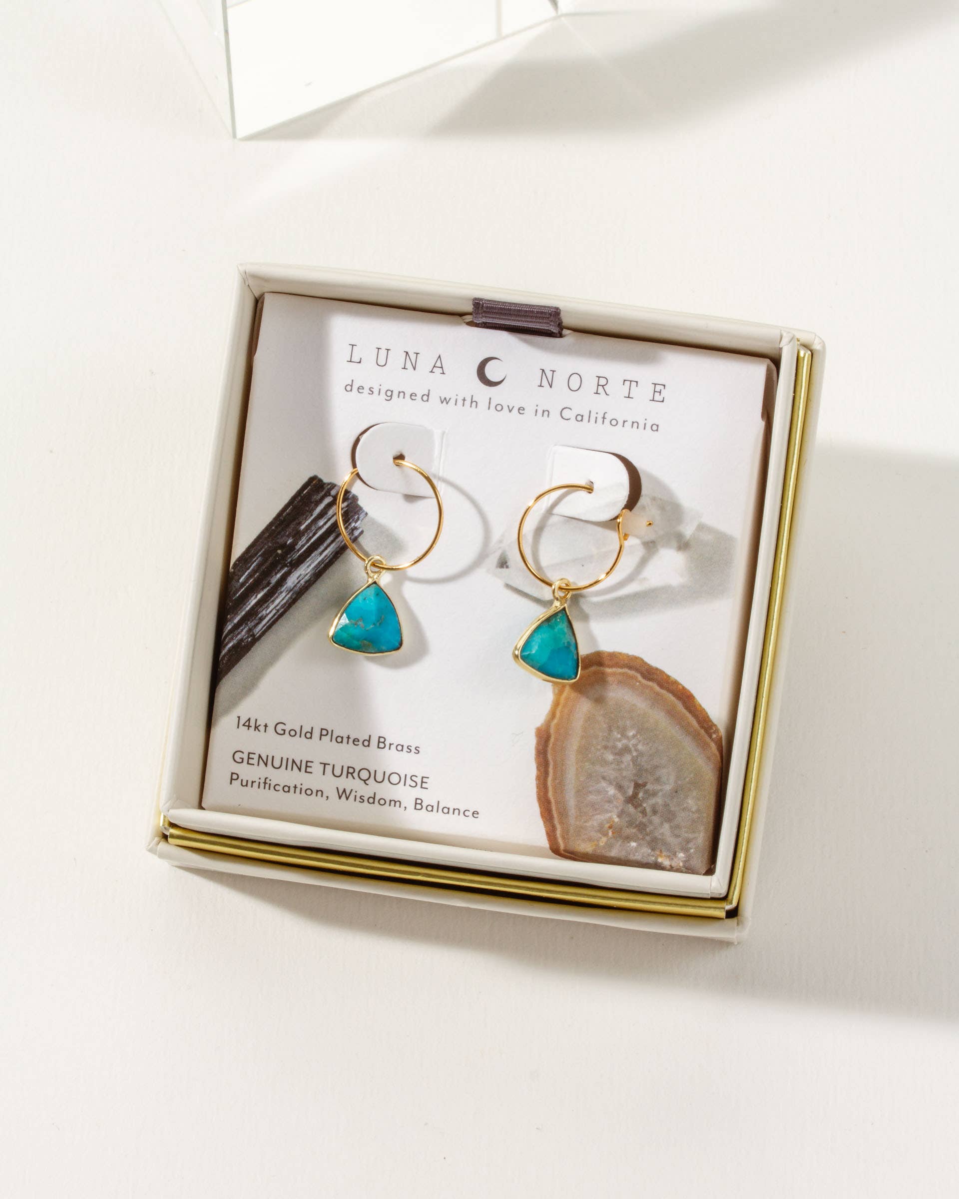 Earrings with turquoise stones and gold plating in a Luna Norte box on a white background