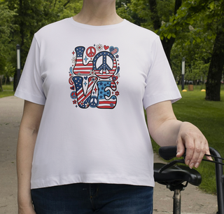 White Patriotic LOVE peace sign t-shirt worn by a person in a park, colorful red white and blue LOVE graphic