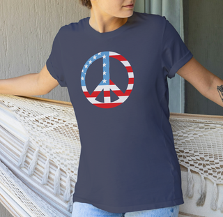 Navy American flag peace sign t-shirt worn by a person sitting on a wooden deck