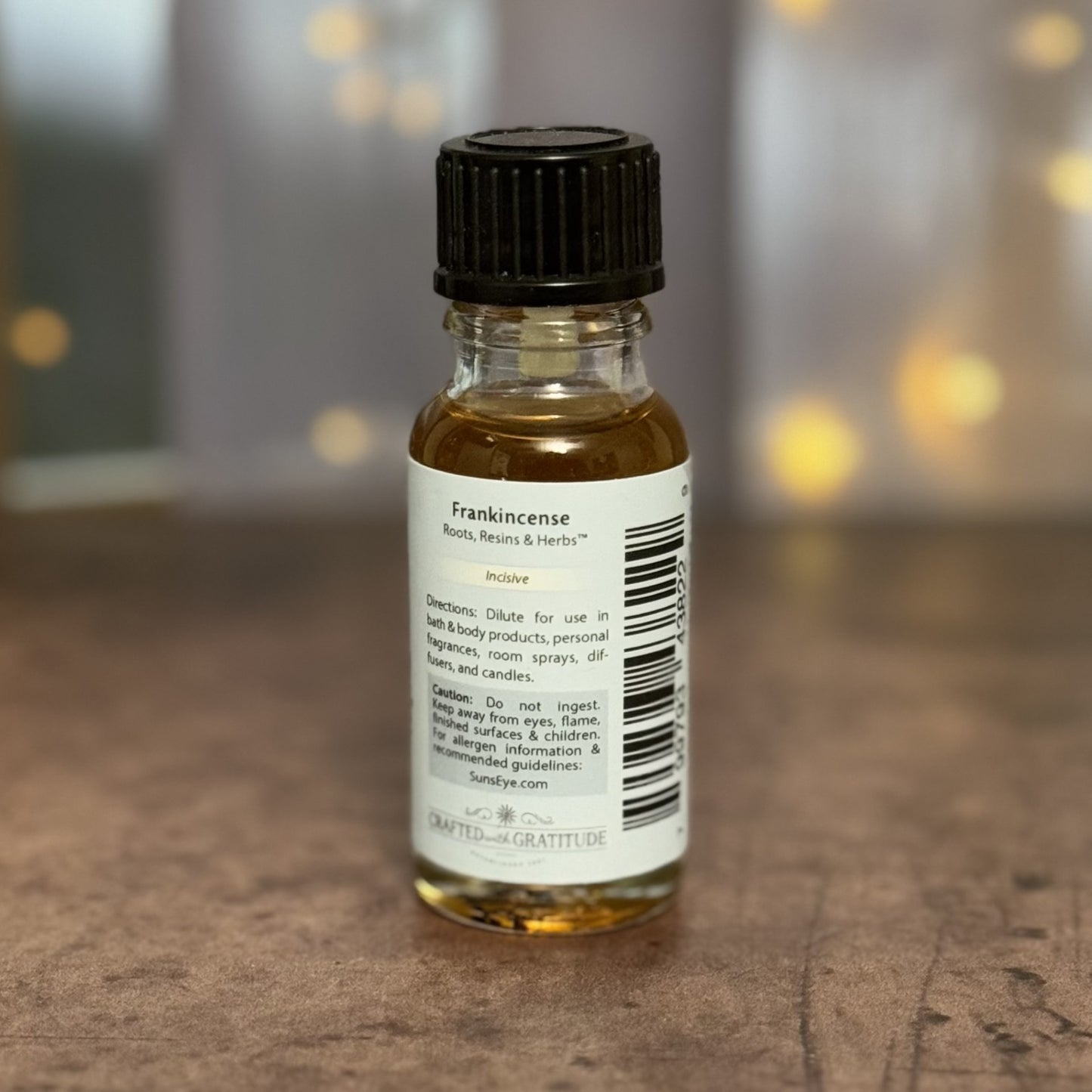 Bottle of frankincense oil with a label on a wooden surface