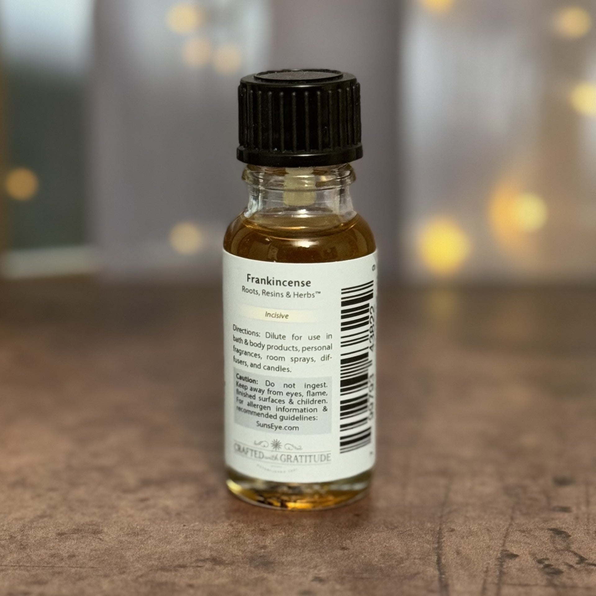 Bottle of frankincense oil with a label on a wooden surface