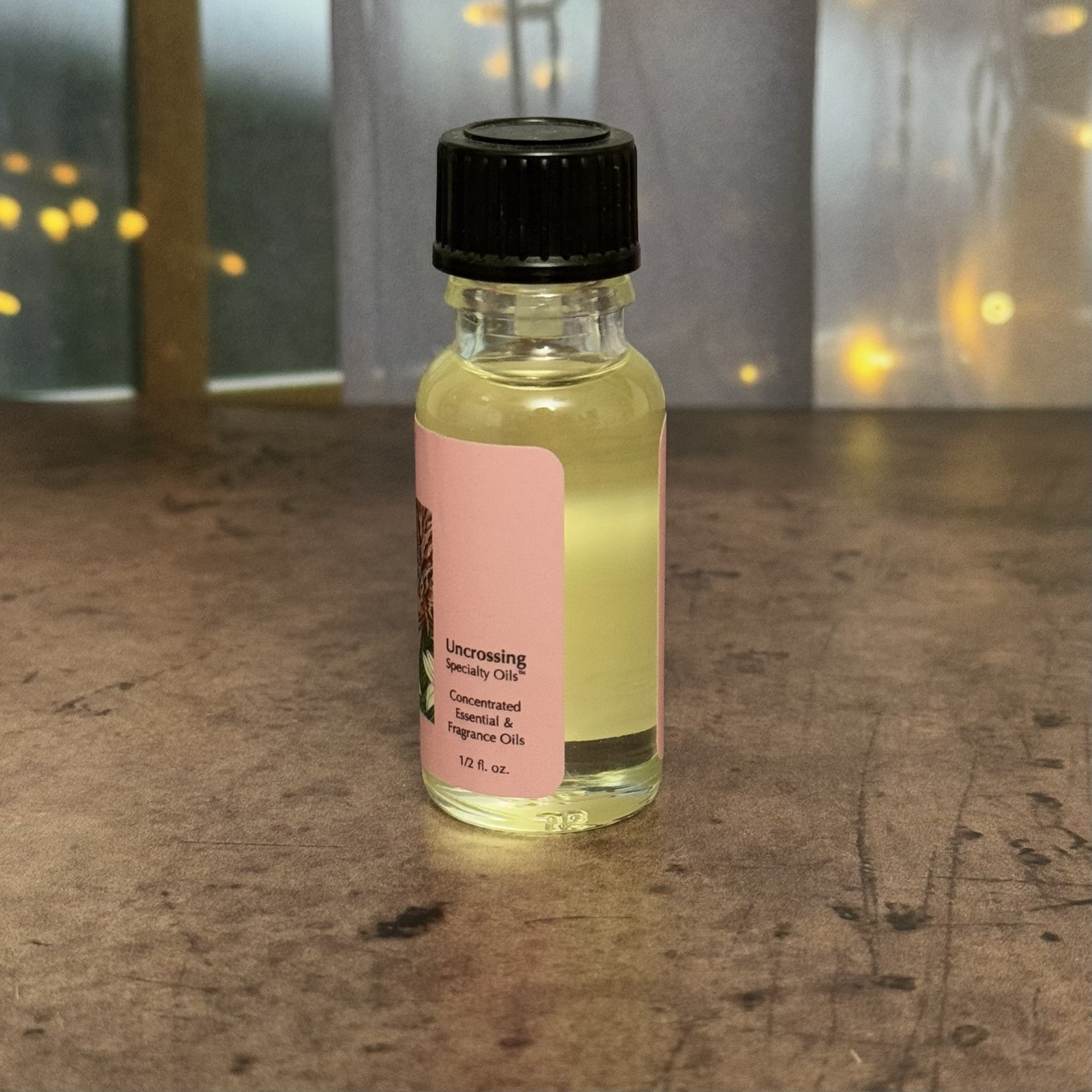 Small bottle of Sun's Eye Oil with a pink label on a textured surface.