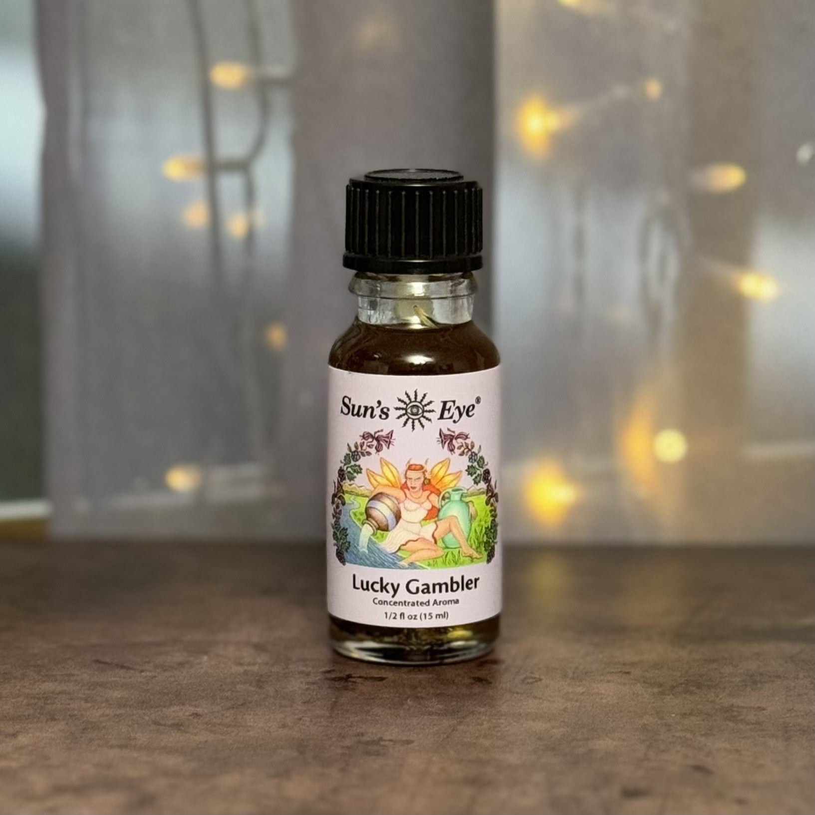 Bottle of Sun's Eye Lucky Gambler concentrated aroma on a wooden surface with a blurred background