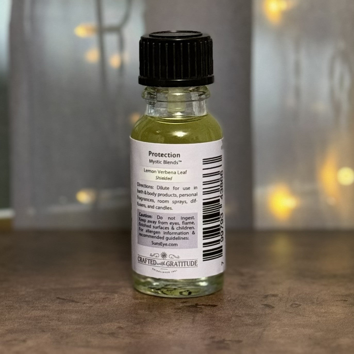 Small bottle with a label on a wooden surface, blurred lights in the background