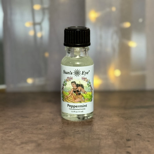 Bottle of Sun's Eye Peppermint essential oil on a wooden surface with a blurred background