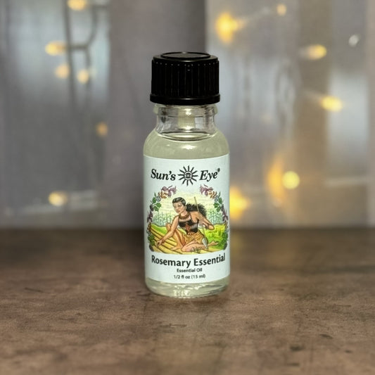 Bottle of Sun's Eye Rosemary Essential Oil on a wooden surface with a blurred background