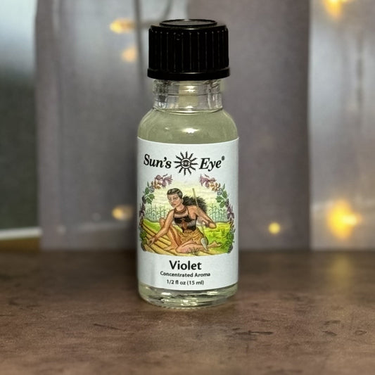 Bottle of Sun's Eye Violet concentrated aroma on a wooden surface with a blurred background