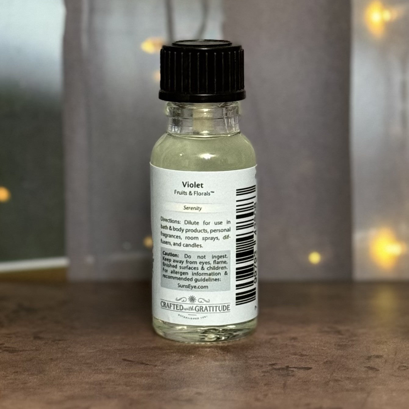 Small glass bottle with a black cap and white label on a wooden surface.