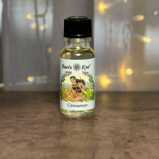 Bottle of Sun's Eye cinnamon oil on a wooden surface with a blurred background