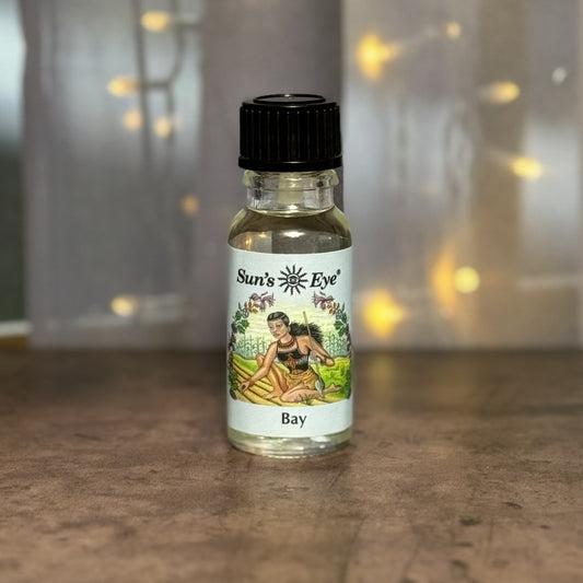 Bottle of Sun's Eye Bay essential oil on a wooden surface with a blurred background