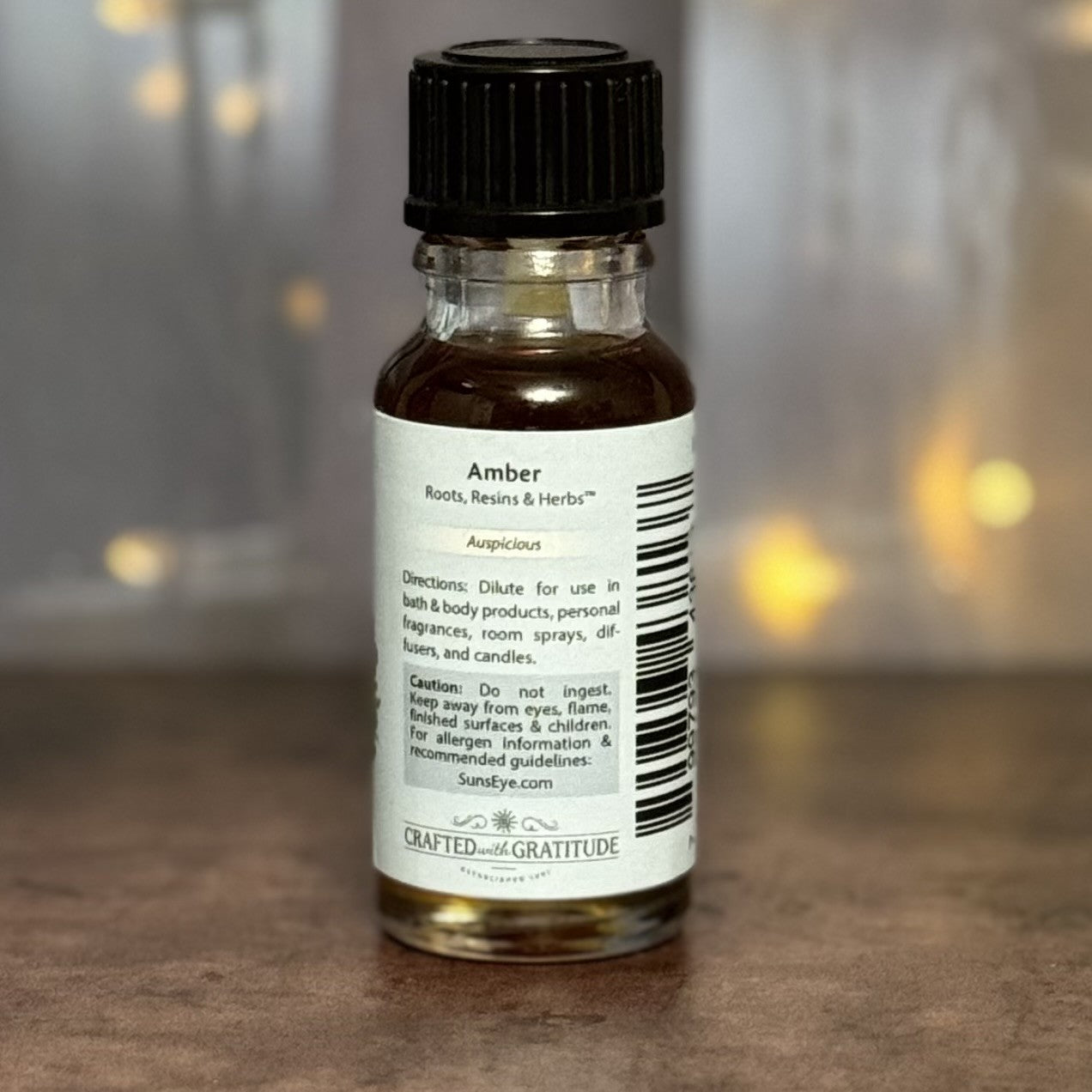 Bottle of amber essential oil with a label on a wooden surface