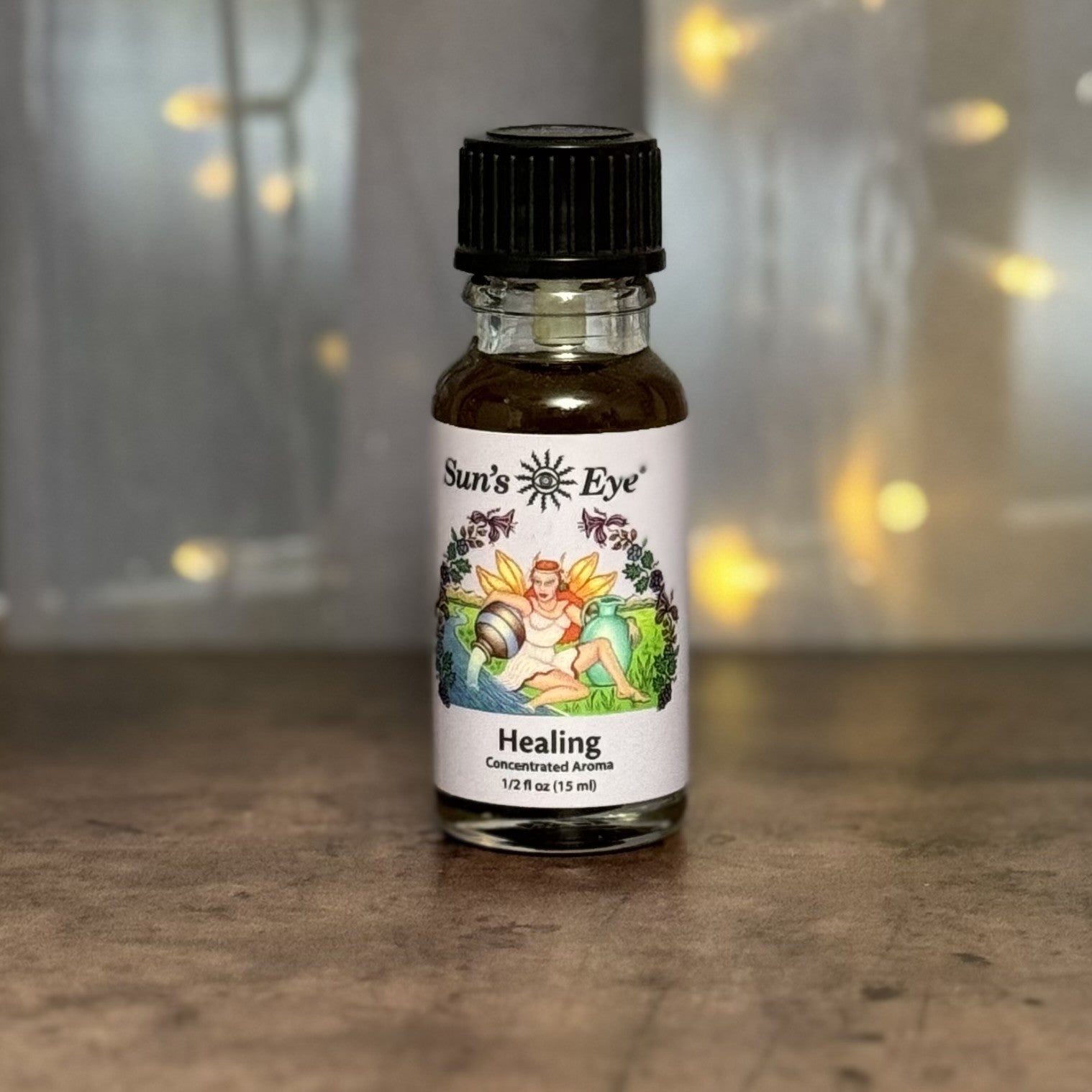 Bottle of Sun's Eye Healing concentrate aroma on a wooden surface with a blurred background