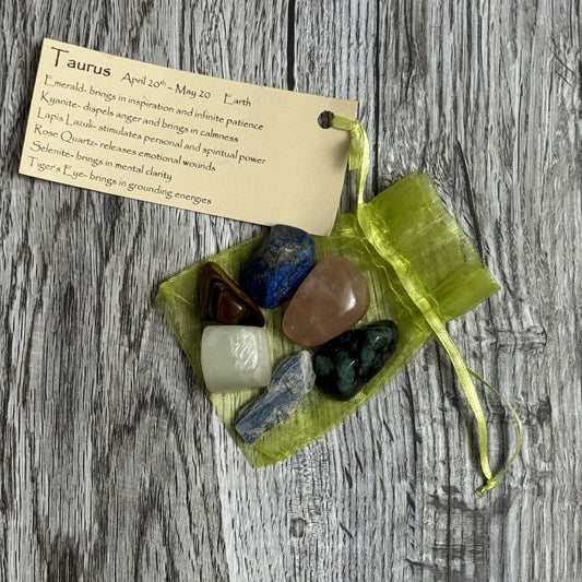 Set of tumbled stones in a green organza bag with a card on a wooden surface