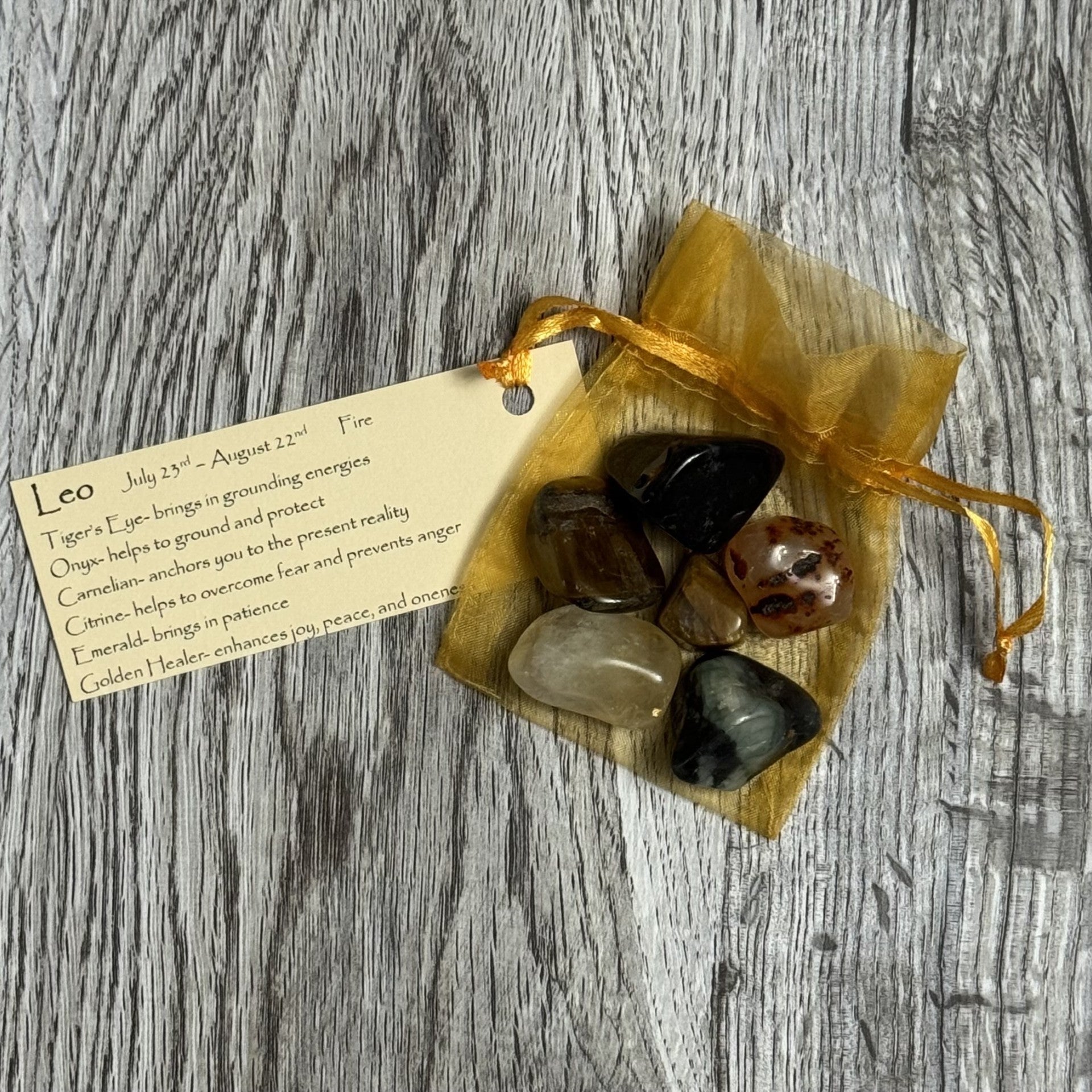 Set of stones in a drawstring bag with a tag on a wooden surface