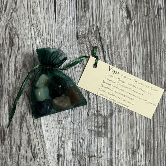Set of stones in a green drawstring bag with a tag on a wooden surface