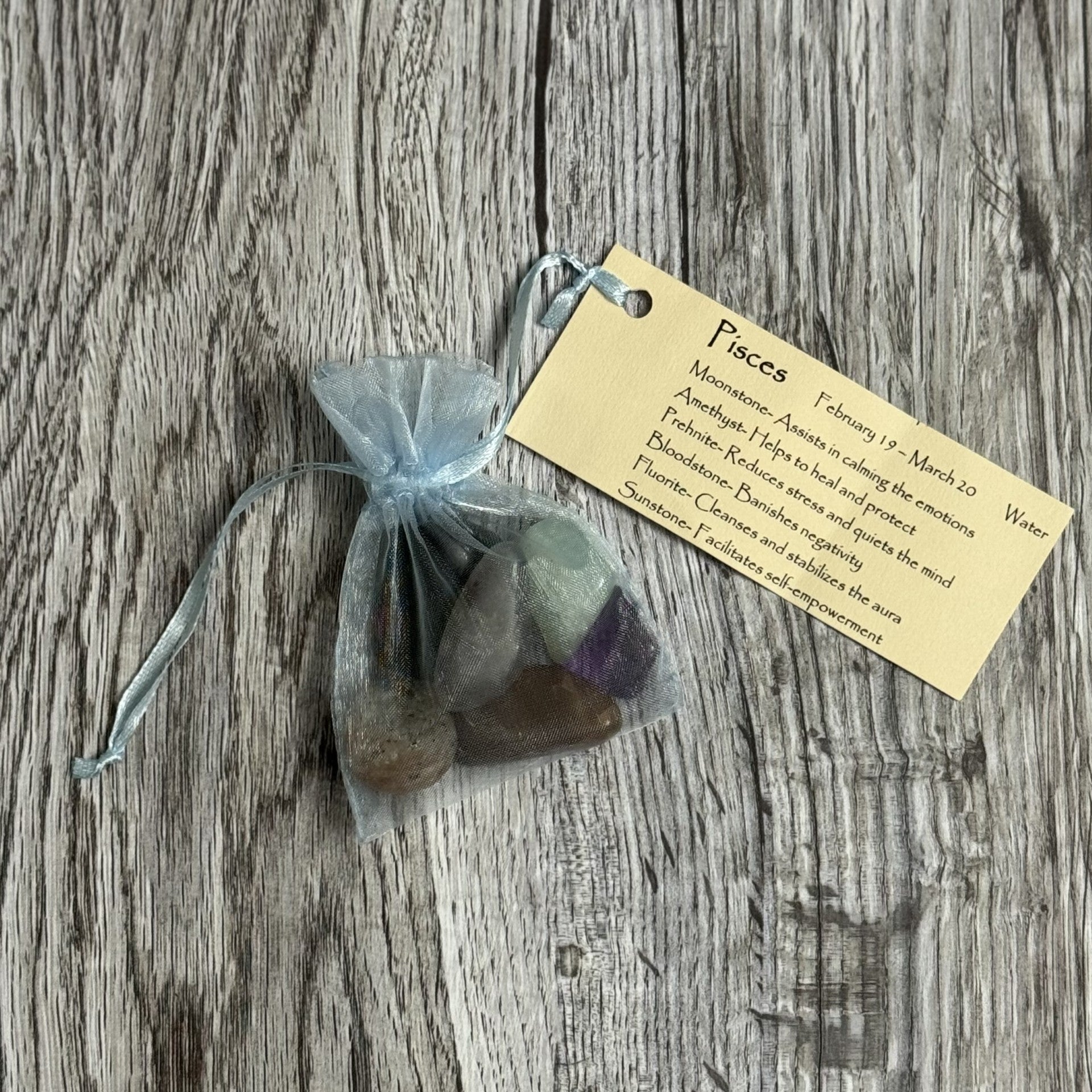 Set of stones in a sheer bag with a tag on a wooden surface