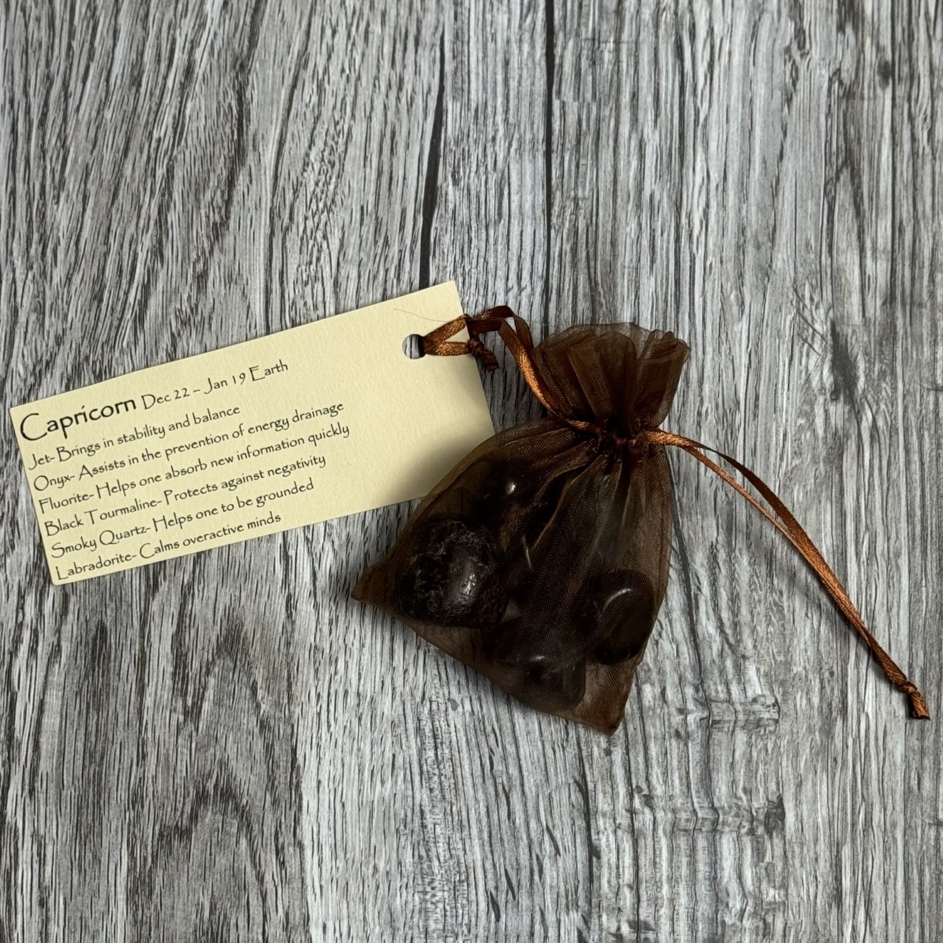 Brown drawstring bag with a card on a wooden surface