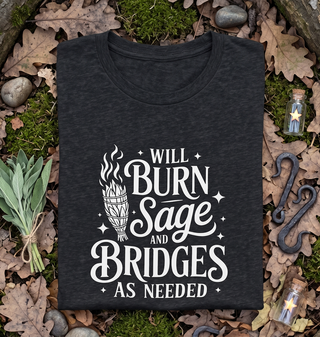 Folded Dark Grey Heather 'Will burn sage and bridges' tee styled with leaves and stones on a natural background